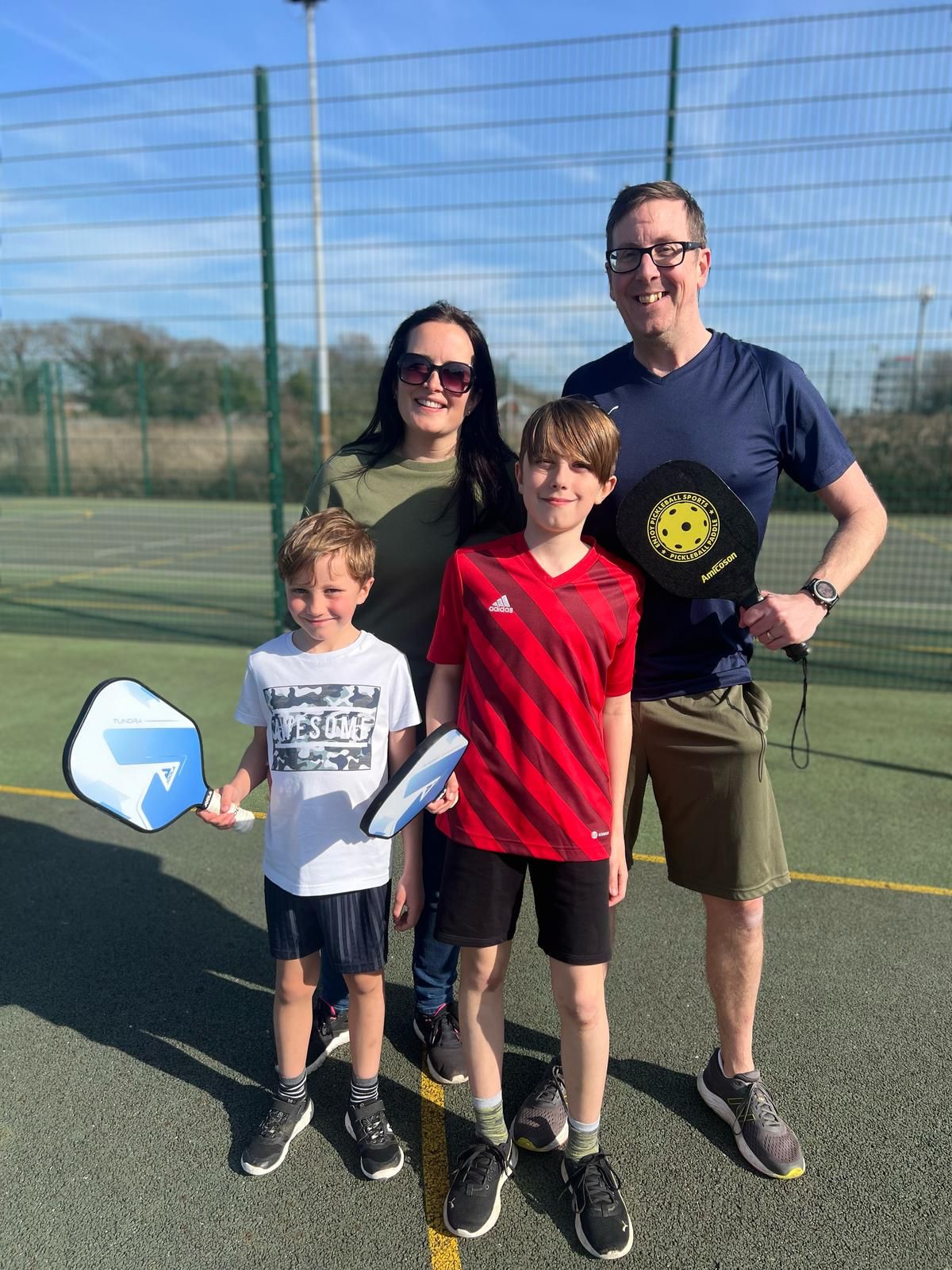 Family with pickleball equipment